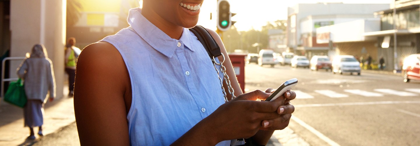 a woman smiling and holding her mobile phone